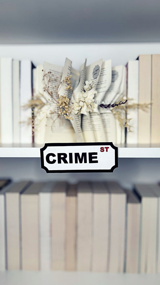 Regalschild „CRIME ST“ in Schwarz-Weiß
