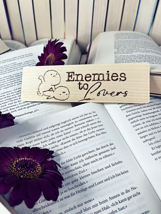 Holzlesezeichen, per Hand gebrannt, mit Schriftzug „Enemies to Lovers“.
